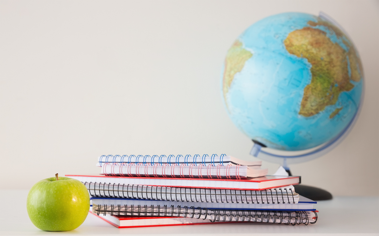 A globe and a stack of notebooks